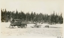 Image of Snowmobile hauling wood to camp